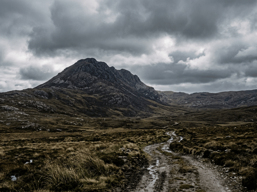Rugged mountain landscape with a winding trail beneath storm clouds